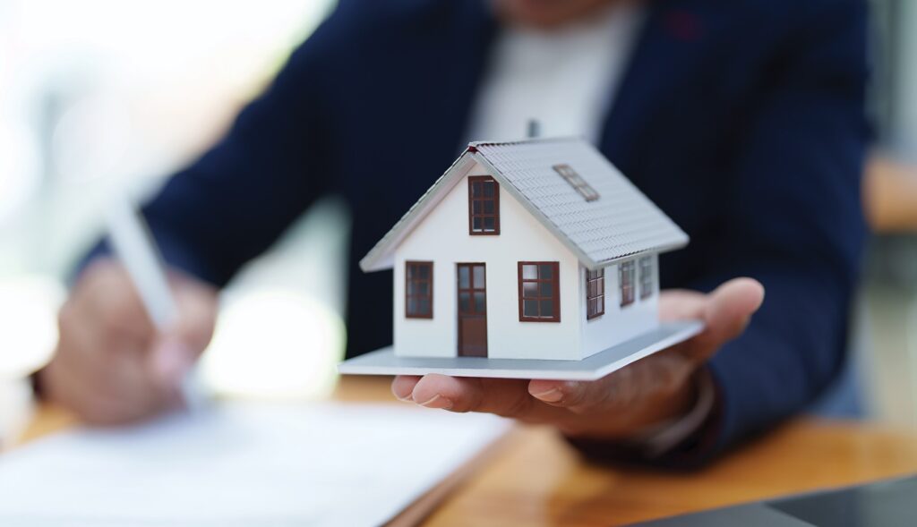 Person holding model-sized house